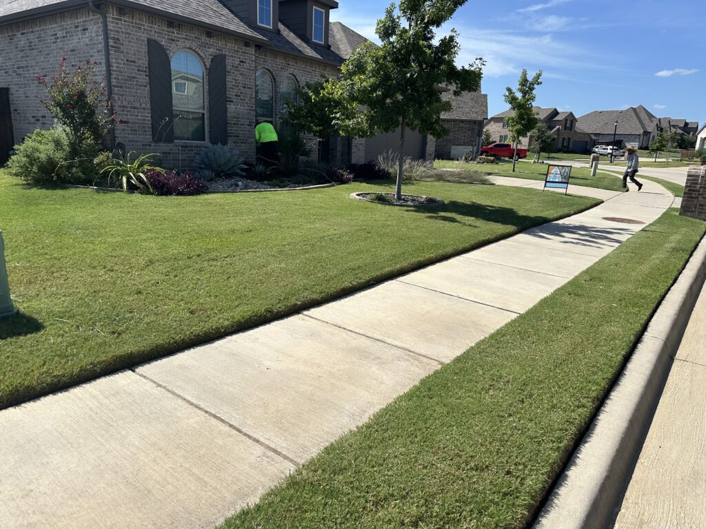 Beautifully maintained front yard in Denison, TX, featuring lush green grass, trimmed edges, and professional landscaping care by Yard Doctor.