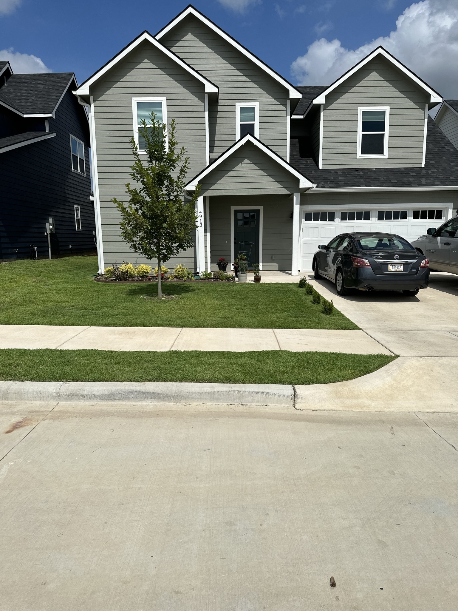 Front yard of a modern home with a neatly mowed lawn and well-maintained landscaping in North Texas, serviced by Yard Doctor.