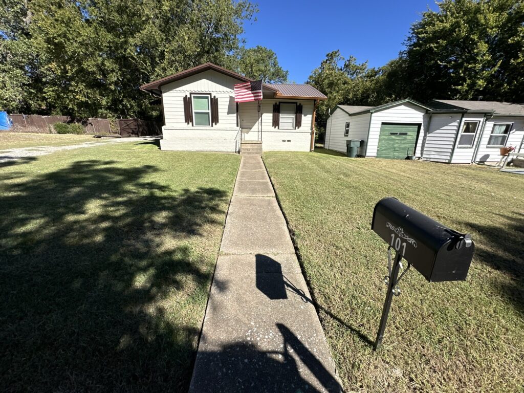 Freshly mowed front yard with neatly trimmed grass in Sherman, TX, maintained by Yard Doctor's professional lawn care services.