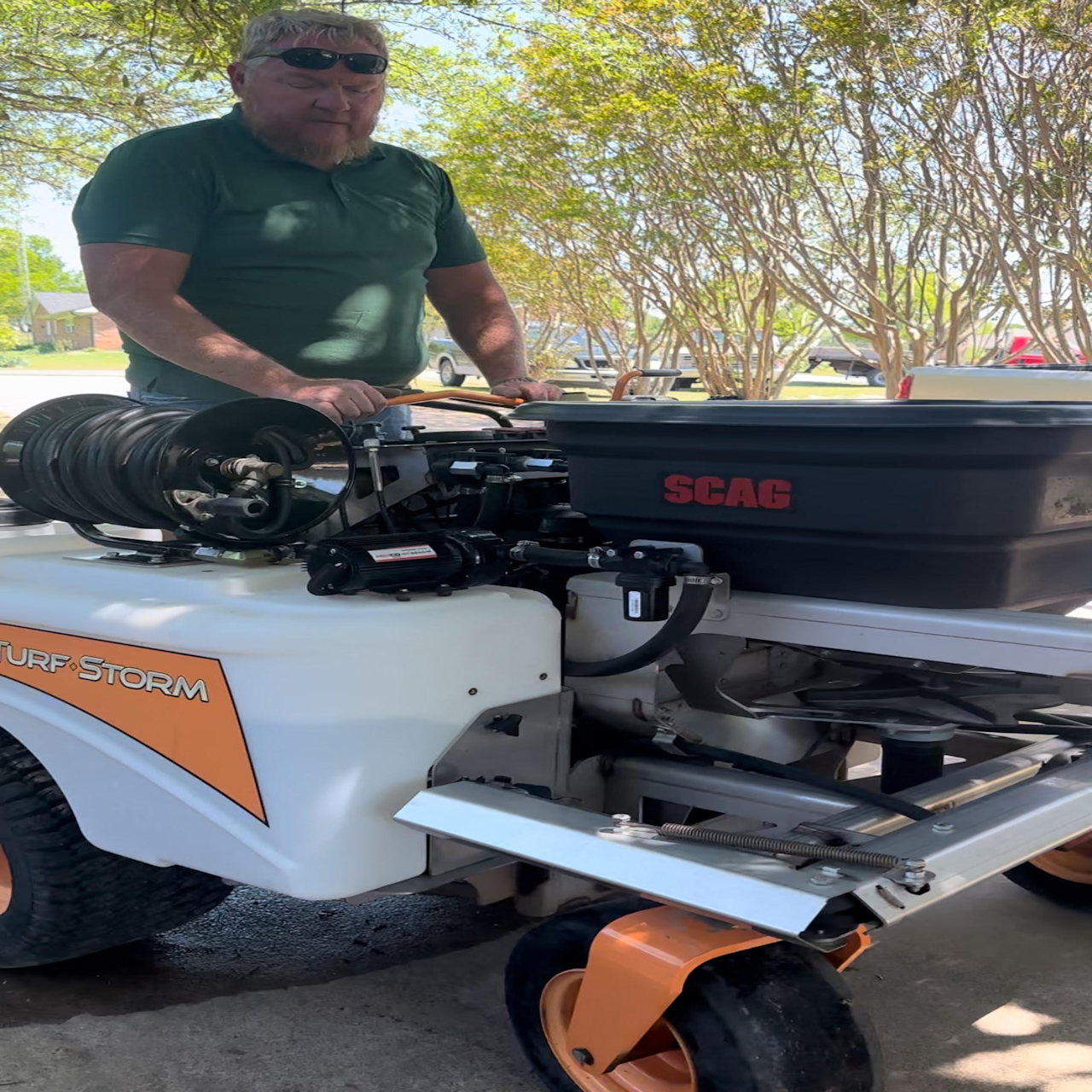 Lawn care professional operating a SCAG TurfStorm sprayer for fertilization and weed control in North Texas.